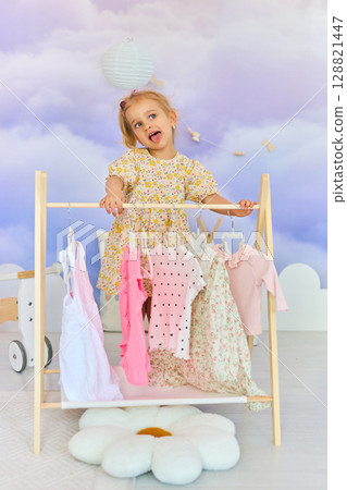 Little child girl choosing her clothes. 128821447