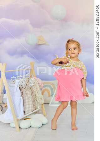 Little child girl choosing her clothes. 128821450