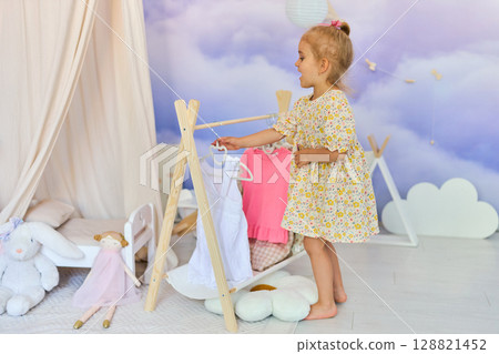 Little child girl choosing her clothes. Little child girl choosing her clothes. 128821452