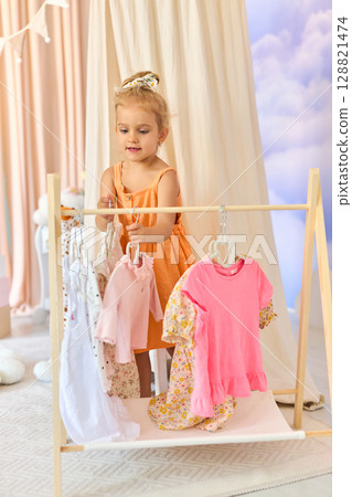 Little child girl choosing her clothes. 128821474