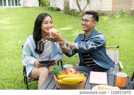 Couple Sharing a Sweet Moment with Pastries in Nature Couple Sharing a Sweet Moment with Pastries in Nature 128821970