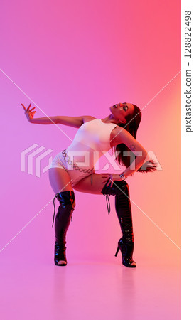 Dynamic jazz funk dancer posing confidently in vibrant studio lighting 128822498