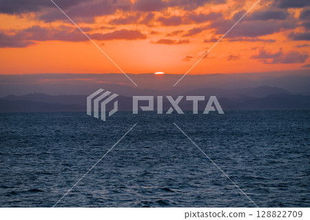 [Tokyo Kyushu Ferry bound for Mayu Shinmoji Port, Sunset off the coast of Uwajima, Cargo ship included] 128822709