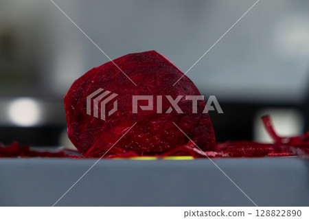 Vibrant half-cut red beet, freshly peeled and prepared on a surface, highlighting healthy eating, natural ingredients, and a raw food diet concept 128822890