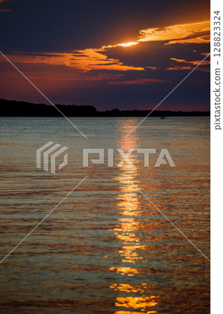 Sky with light clouds over the sea. Beautiful sunset on a summer evening. Ships 128823324