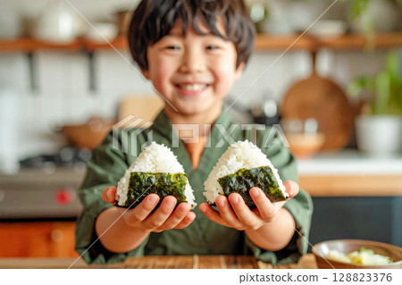 一個男孩雙手抱飯糰 128823376