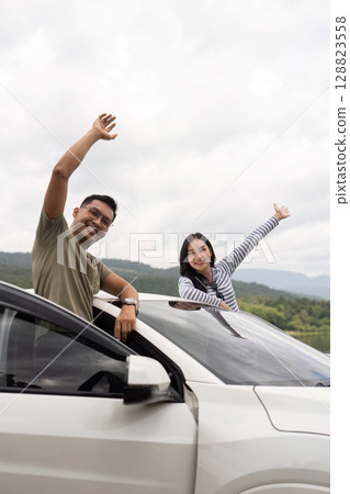 Couple enjoying the view from their car Couple enjoying the view from their car 128823558
