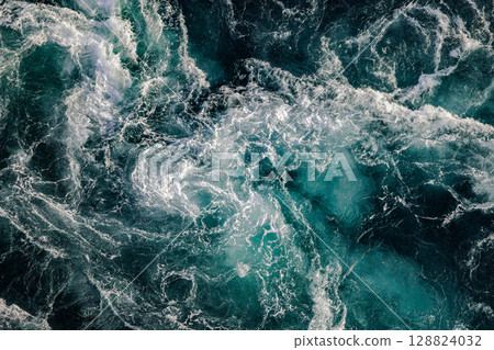 Blue waves of water of the river and the sea meet each other during high tide and low tide. 128824032