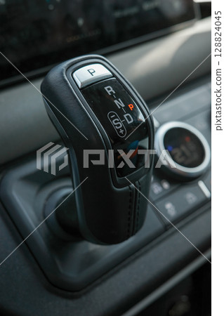 A gear shift with the letters P, N, and D on it. The shift is black and has a leather finish A gear shift with the letters P, N, and D on it. The shift is black and has a leather finish 128824045