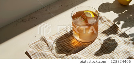 Refreshing summer kombucha served on a rustic picnic table with fresh lemon and ice 128824406