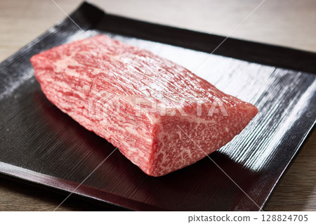 奢華食材的照片,一塊A5級黑毛和牛大腿肉盛放在黑色的方形盤子裡 奢華食材的照片,一塊A5級黑毛和牛大腿肉盛放在黑色的方形盤子裡 128824705