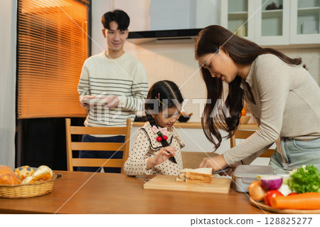 Smiling Asian family enjoying breakfast in weekend morning. 128825277
