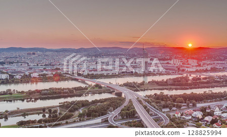 Aerial panoramic view of sunset over Vienna city with skyscrapers, historic buildings and a riverside promenade timelapse in Austria. Aerial panoramic view of sunset over Vienna city with skyscrapers, historic buildings and a riverside promenade timelapse in Austria. 128825994