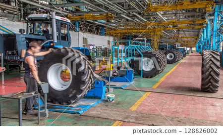 Professional mechanic install tire on wheel in repair service on tractor factory timelapse. Professional mechanic install tire on wheel in repair service on tractor factory timelapse. 128826002