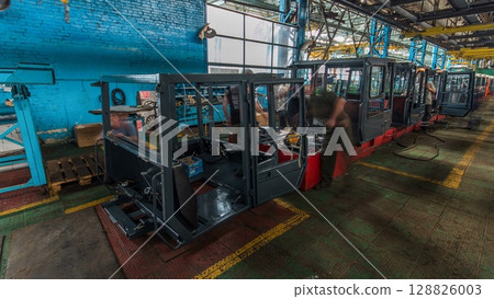 Conveyor assembly stage the body of tractor at big industrial factory timelapse Conveyor assembly stage the body of tractor at big industrial factory timelapse 128826003