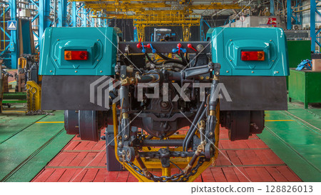 Conveyor assembly stage the body of tractor at big industrial factory timelapse Conveyor assembly stage the body of tractor at big industrial factory timelapse 128826013