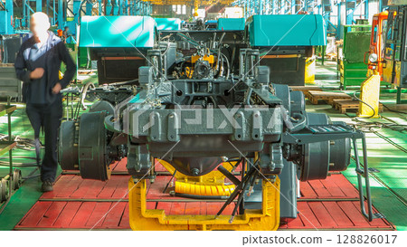 Conveyor assembly stage the body of tractor at big industrial factory timelapse Conveyor assembly stage the body of tractor at big industrial factory timelapse 128826017
