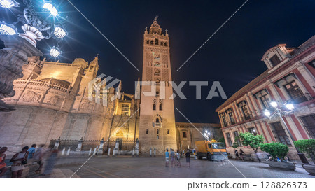 La Giralda and Seville Cathedral timelapse hyperlapse glowing under the night sky. La Giralda and Seville Cathedral timelapse hyperlapse glowing under the night sky. 128826373