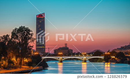 Seville skyline day to night timelapse with Torre Sevilla and Triana Bridge 128826379