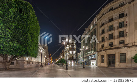 Illuminated Adriatica building on Avenida de la Constitucion at night, Seville, Spain 128826675