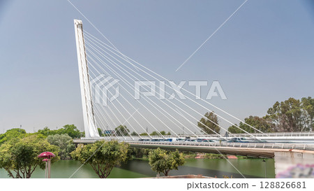 Alamillo Bridge with tall pylon and steel cables crossing over Guadalquivir River timelapse hyperlapse in Seville, Spain 128826681