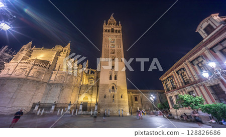 La Giralda and Seville Cathedral timelapse hyperlapse glowing under the night sky. La Giralda and Seville Cathedral timelapse hyperlapse glowing under the night sky. 128826686