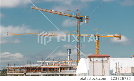 Timelapse of construction site with cranes working on a building complex. 128826783