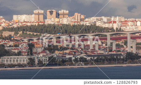 Aerial timelapse of Lisbon skyline featuring colorful houses, Amoreiras shopping center towers and the 25th of April Bridge. Aerial timelapse of Lisbon skyline featuring colorful houses, Amoreiras shopping center towers and the 25th of April Bridge. 128826793