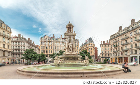 Hyperlapse of Place des Jacobins in Lyon, France, featuring the ornate Fontaine des Jacobins surrounded by historic buildings. 128826827
