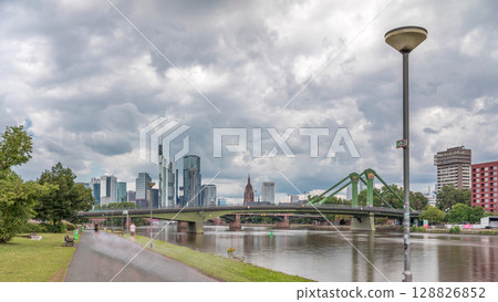 Hyperlapse of Frankfurt's Main Iron Footbridge against the financial district skyscrapers skyline on a sunny day with clouds timelapse. Frankfurt, Germany 128826852
