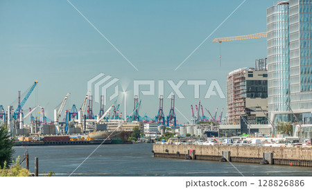 Timelapse of Hamburg cargo port, showcasing container terminals, cranes and cargo ships on the Elbe River. 128826886