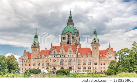 Hyperlapse of Hanover's New Town Hall, a landmark castle-like structure surrounded by park and lake under a cloudy sky. Germany 128826903