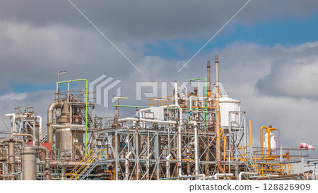 Distillation Columns and their process equipment of hydrogen plant timelapse with clouds on a background. 128826909