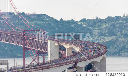 Running Lisbon half marathon crossing the 25 of April bridge over the Tagus river aerial timelapse view from above. Running Lisbon half marathon crossing the 25 of April bridge over the Tagus river aerial timelapse view from above. 128826910