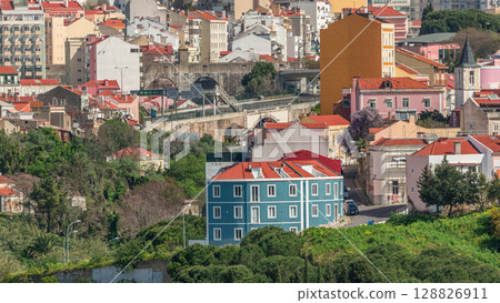 Aerial view of Lisbon skyline with road and aqueduct. Historic buildings near Campo de Ourique district with green trees timelapse 128826911
