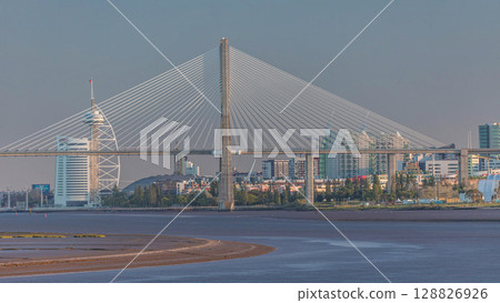 Vasco da Gama Bridge over river Tagus timelapse in Lisbon with park of Nations district modern architecture, Portugal Vasco da Gama Bridge over river Tagus timelapse in Lisbon with park of Nations district modern architecture, Portugal 128826926