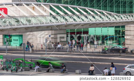 People crossing a street on a zebra crossing in front of the Vasco da Gama shopping center aerial timelapse. Lisbon, Portugal 128826932
