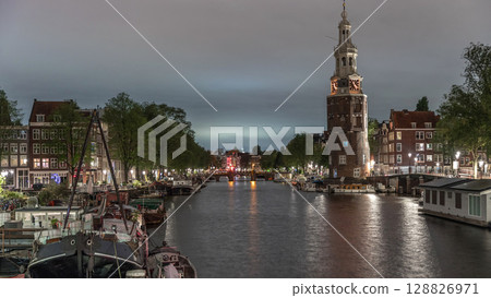 City panorama of Amsterdam night timelapse featuring the Montelbaanstoren tower. Netherlands 128826971
