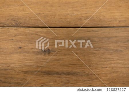 Close-up view of rustic wooden flooring highlighting natural grain and texture in a well-lit space Close-up view of rustic wooden flooring highlighting natural grain and texture in a well-lit space 128827227