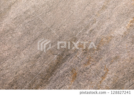 Textured surface of natural stone with subtle color variations observed in natural light 128827241