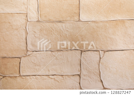 Textured stone wall with beige tones and unique patterns in a contemporary setting Textured stone wall with beige tones and unique patterns in a contemporary setting 128827247