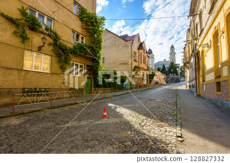 uzhhorod, ukraine - 11 jun 2017: european urban landscape with street of town in morning light. cobblestone path up the hill to holy cross cathedral 128827332