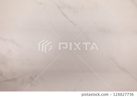 Smooth white marble surface with subtle gray veining creating a clean and elegant backdrop Smooth white marble surface with subtle gray veining creating a clean and elegant backdrop 128827736