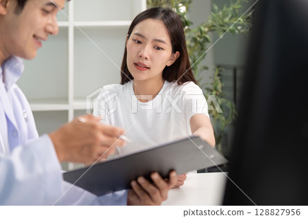 Doctor providing detailed explanation to a patient about health conditions. Doctor providing detailed explanation to a patient about health conditions. 128827956