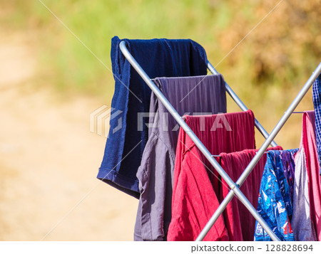 Clothes hanging to dry on drying rack outdoors 128828694