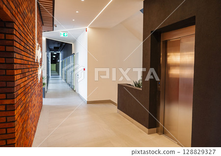 Long Hallway With Metal Door and Planter 128829327