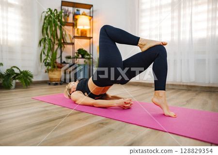 Practicing yoga poses for strength and flexibility in a serene space 128829354