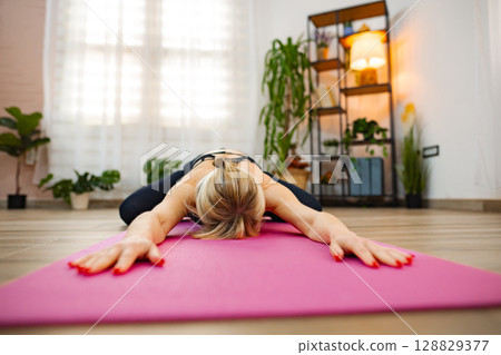Engaging in relaxed yoga practice during a calming indoor session 128829377