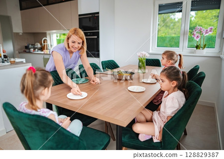 Kids enjoying a meal together in a cozy kitchen setting 128829387