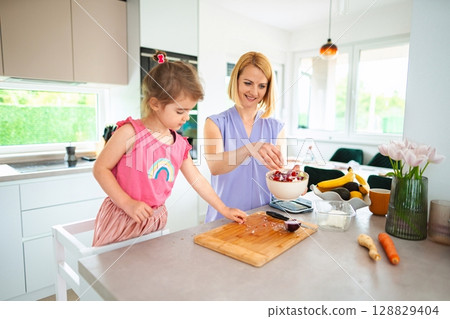 Joyful moments of cooking together in a bright kitchen 128829404